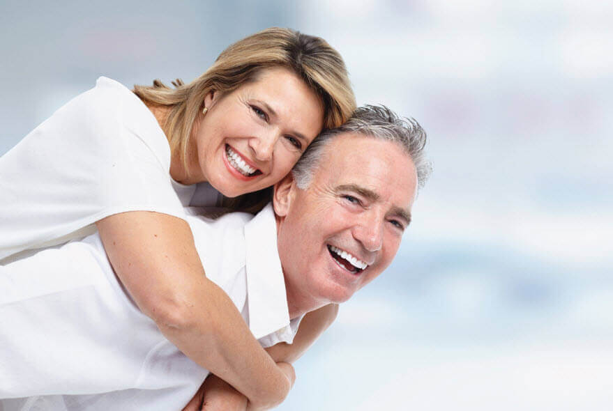 Smiling mature couple who replaced their missing teeth